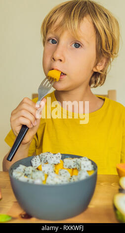 Boy eats fruit. Healthy food for children. Child eating healthy snack. Vegetarian nutrition for kids. Vitamins for children VERTICAL FORMAT for Stock Photo