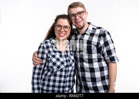 Nerds, bespectacled and funny people concept - funny couple in glasses are hugging on white background. Stock Photo