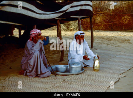 Arab folklore and history with Emirati men enjoying a coffee break during the Dubai Trade Festival in the United Arab Emirates Stock Photo