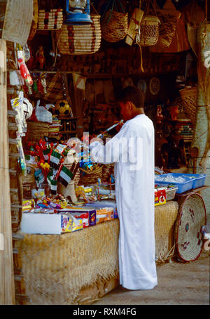 Arab folklore and history with a young man shopping during the Dubai Trade Festival in the United Arab Emirates Stock Photo