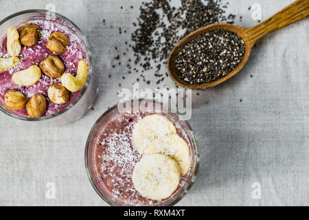 Smoothie bowl breakfast, shot from above. Healthy organic raw food meals in natural rustic background Stock Photo
