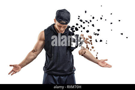 Young muscular man in black sport clothing shattering into small pieces on white background Stock Photo