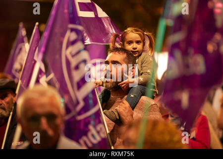 CORDOBA, SPAIN - 03, 08, 2019: Father carrying his daughter on his shoulders at the Women's Day demonstration. Stock Photo