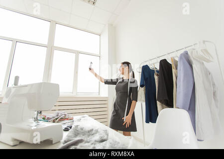 Dressmaker, technologies, fashion designer and tailor concept - Fashion designer taking selfies over mannequin background Stock Photo