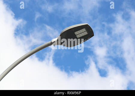 LED street lamp isolated on blue sky with white clouds. Modern led lights, saving electrical energy Stock Photo