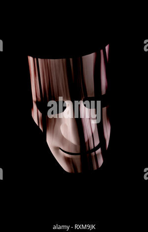 Scary face mask with hair hanging over face. Dark black background. Halloween or horror or underground crime concept