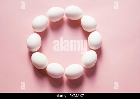 White eggs in a circle on pink background Stock Photo