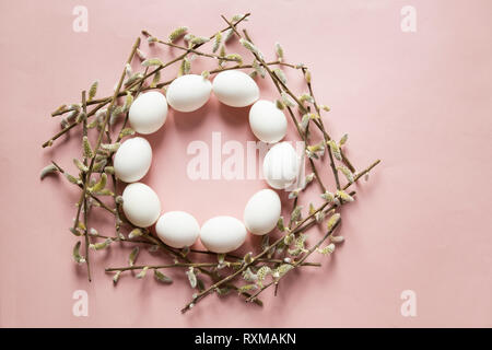 Eggs and willow branches on pink background Stock Photo