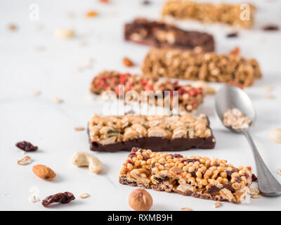 Granola bar with copy space. Set of different granola bars on white marble table. Shallow DOF. Stock Photo