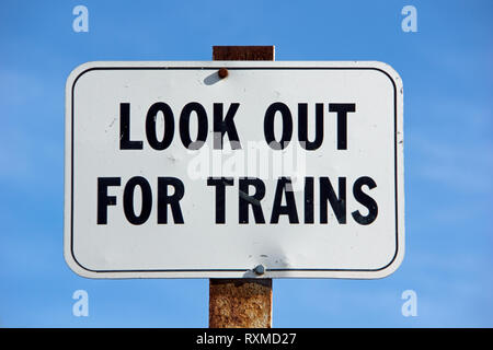 Abstract train warning sign with ‘Look out for trains’ in black