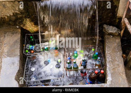 Khorog, Tajikistan August 25 2018: At the roadside on the Pamir Highway in Tajikistan drinks are cooled under a small waterfall Stock Photo