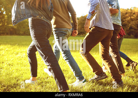 Legs of people running in the meadow. Stock Photo