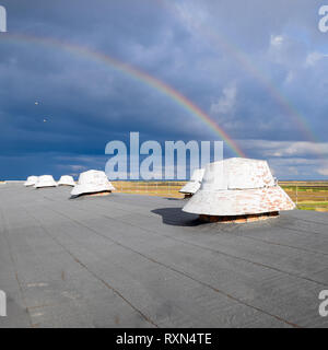 Rainbow, view from the roof of the building. Ventilation outlets on the roof of the building. Stock Photo
