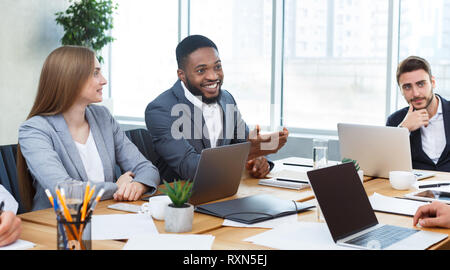 Young business team analysing graphs and charts at meeting Stock Photo