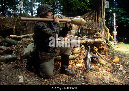 A WW2 Reenactor wears the period uniform of a Waffen SS soldier he fires a Panzerfaust anti tank weapon. Stock Photo