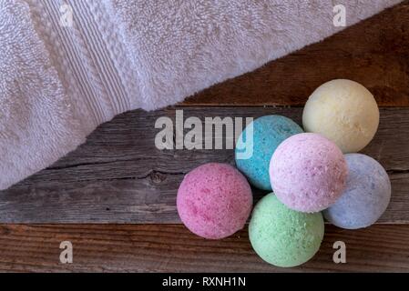 Colorful bath bombs with accessories on weathered wood. Stock Photo