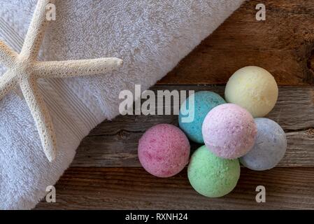 Colorful bath bombs with accessories on weathered wood. Stock Photo