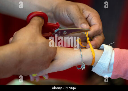 Tibetan monk while putting bracelet on buddihst hand detail Stock Photo