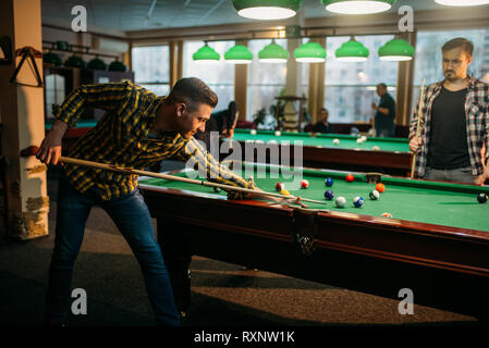 Two male billiard players spend time in poolroom Stock Photo