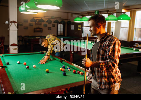 Two male billiard players with cues poses Stock Photo