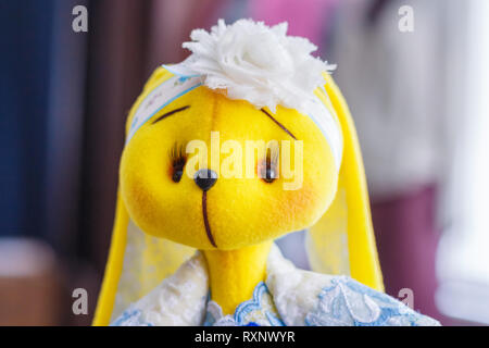 Handmade yellow doll bunny close-up in blue dress Stock Photo