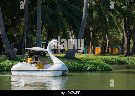 Tourists in swan pedal boat in Bangkok Lumpini park, Thailand Stock Photo