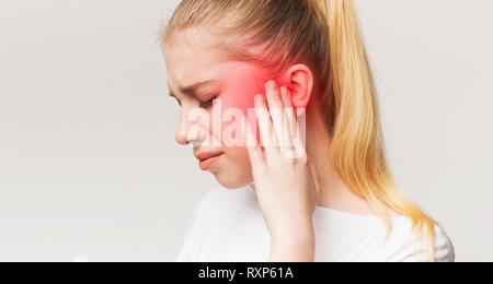 Woman having ear pain, touching her painful head Stock Photo