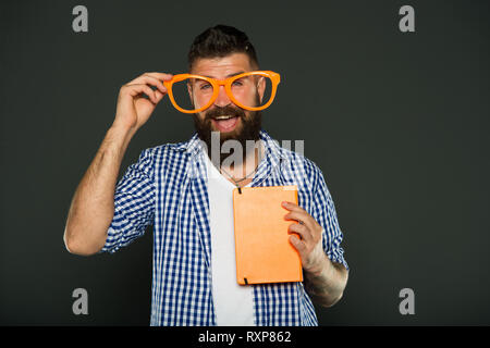 Super smart. University male student with lecture notes. Book nerd wearing fancy glasses. Bearded man in party glasses with lesson book. Study nerd holding book. Stock Photo