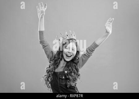 Feels like queen. Kid wear golden crown symbol of princess. Lady little princess. Girl cute baby wear crown while stand blue background. Childhood concept. Every girl dreaming to become princess. Stock Photo