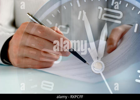 Businessman working to a deadline on paperwork in a conceptual image overlaid over the dial of a clock showing five to twelve Stock Photo