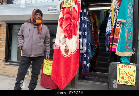 A vendor  on 74th Street in Jackson Heights, Queens, New York City who tries to lure customers into his upstairs shop. Stock Photo