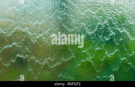 Wall of falling water on green, brown and white background Stock Photo