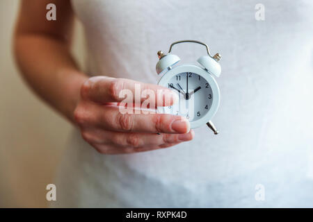 Female woman hands holding ringing twin bell vintage classic alarm clock. Rest hours time of life good morning night wake up awake concept Stock Photo