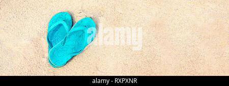 Blue pair of flip flops on the beach, panoramic summer concept Stock Photo
