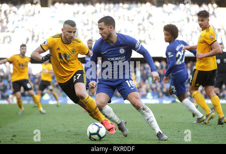 Wolverhampton Wanderers' Romain Saiss (left) and Chelsea's Eden Hazard battle for the ball during the Premier League match at Stamford Bridge, London. Stock Photo