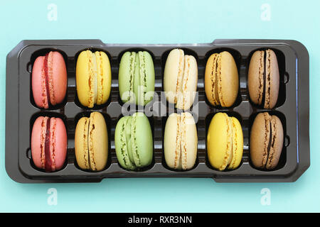 Colorful crunchy macaroons on black plastic box, shot from the top Stock Photo