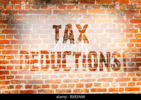 Conceptual hand writing showing Tax Deductions. Concept meaning Reduction on taxes Investment Savings Money Returns Brick Wall art like Graffiti motiv Stock Photo