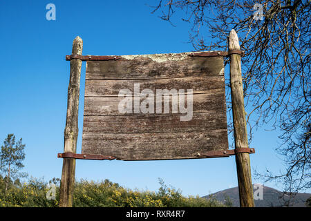 Old weathered wooden sign on nature and blue sky. Mock up Stock Photo