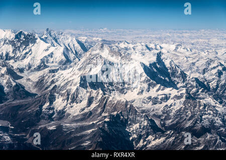 Aerial view of the snow capped Himalayas mountain in Nepal from a plane on a sunny winter day Stock Photo