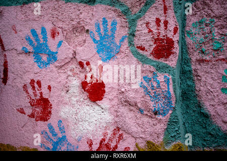 backgrounds with texture of old house wall with paint layers and painted hands Stock Photo