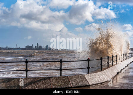 New Brighton, Merseyside, UK. 10th Mar 2019. Waves batter the Egremont promenade on the river Mersey  with Liverpool skyline in the background during the high winds. Credit: John Davidson/Alamy Live News Stock Photo