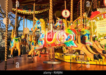 South Bank, London, UK. 10th Mar 2019. The colourful wooden horses and ornaments on a funfair carousel on the South Bank glow in the warm evening sunlight, following a day of sunshine and showers. Credit: Imageplotter/Alamy Live News Stock Photo