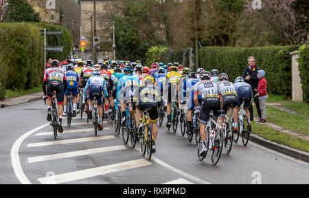Beulle, France - March 10, 2019: Rear view of the peloton riding on Cote de Beulle during the stage 1 of Paris-Nice 2019. Stock Photo
