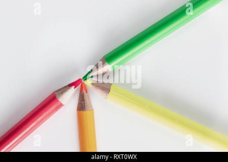 Four neon pencils crayons laid out on a white background Stock Photo
