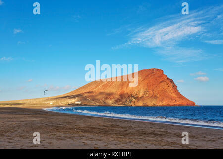 Deserted beach Playa de la Tejita with red mountain Montana Roja, Tenerife, Spain Stock Photo