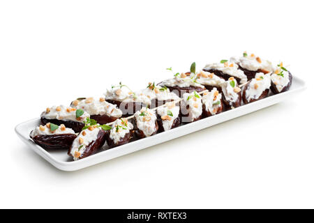 Dates  stuffed with cream cheese and almonds isolated on white Stock Photo