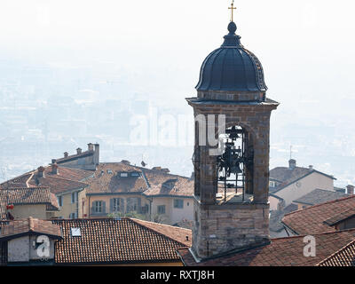Travel to Italy - above view of bell tower of St Alexander Cathedral (Duomo) over urban houses from Campanone (Torre civica) belltower in Citta Alta ( Stock Photo