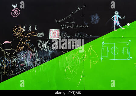 Childrens scribble chalk on a blackboard in the inclusive gaming park of the city Stock Photo