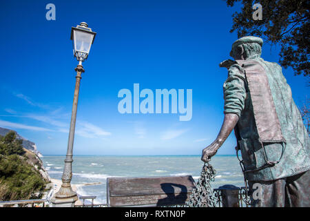 Statue of fisherman guarding the sea -  Numana Sirolo Ancona Marche Italy and Due Sorelle beach. Stock Photo