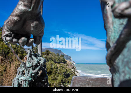 Statue of fisherman guarding the sea -  Numana Sirolo Ancona Marche Italy and Due Sorelle beach. Stock Photo